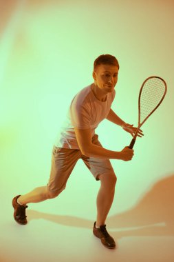 Zevkle squash oynayan heyecanlı bir sporcunun tam boy portresi. Aktif yaşam tarzı. Spor ve sağlık hizmetleri. Stüdyo resmi.