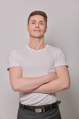 Kameraya bakıp gülümseyen yakışıklı bir adamın portresi. Stüdyoda poz veren atletik adam. Erkek Sağlığı.