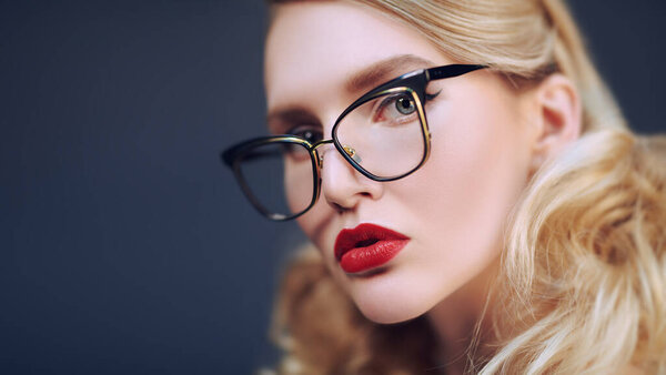 Крупный план портрета блондинки в элегантных очках. Оптика. Бизнес стиль. 