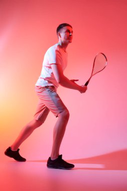 Spor ve sağlık hizmetleri. Zevkle squash oynayan heyecanlı sporcu. Aktif yaşam tarzı. Stüdyo resmi.