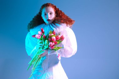 Uzun kırmızı kıvırcık saçlı zarif bir bayanın sanat portresi. Geç rönesans dalgalı yaka ve lalelerle beyaz bir elbise içinde poz veriyor. Sanat moda tarihi.  