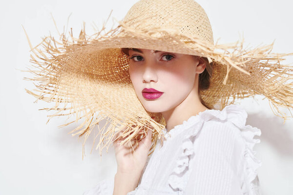 Portrait of a beautiful romantic girl in a straw hat. Summer season. Beauty and cosmetics.