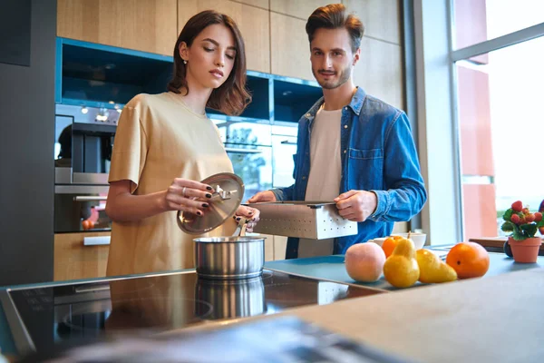 Gençler mutfakta birlikte kahvaltı hazırlıyorlar. Evin içi, mobilyalar. Mutlu aile kavramı.