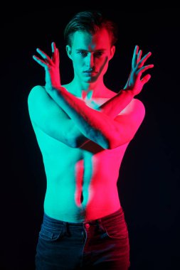 Kırmızı ve yeşil ışıkta çıplak bedeniyle poz veren yakışıklı bir genç adamın sanat portresi. İnsanın güzelliği ve sağlığı. Resim..