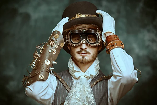 Fantasy world, scientific inventions. Portrait of a handsome victorian steampunk man on a grunge background.