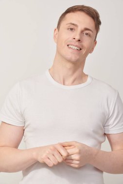 Kameraya bakıp gülümseyen yakışıklı bir adamın portresi. Stüdyoda poz veren atletik adam. Erkek Sağlığı.