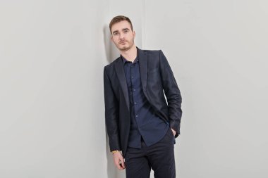 Beyaz arka planda koyu mavi takım elbiseli yakışıklı bir adamın portresi. İş adamı portresi. Boşluğu kopyala.