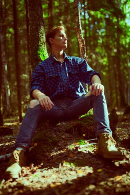 Vahşi ormanda yakışıklı, erkeksi bir adam. Macera, özgürlük ruhu. Etkin yaşam biçimi. 