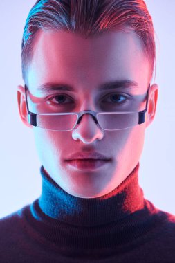 Modern gözlüklü, pembe ışıklı yakışıklı bir adamın portresi. Erkek aksesuarları, optikler. Gözlük stili. 