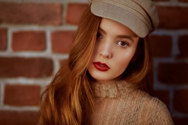 Doğal makyajlı, açık bej elbiseli ve şapkalı güzel bir kızın portresi. Güzellik, moda konsepti. 