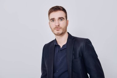 Açık gri arka planda koyu mavi takım elbiseli üzgün ve olgun bir adamın portresi. İş adamı portresi. Boşluğu kopyala.