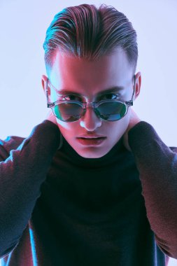Erkek aksesuarları, optikler. Modern güneş gözlüklü yakışıklı genç adam. Stüdyo resmi. 