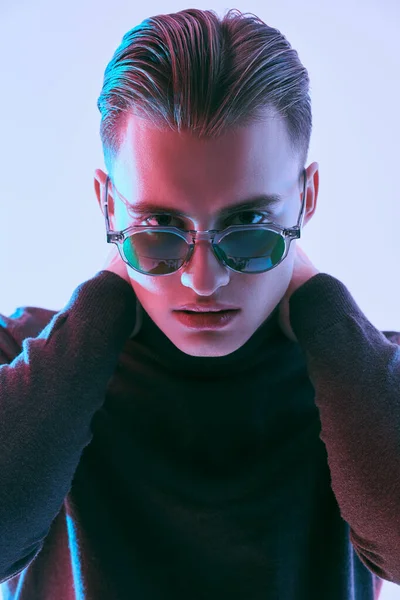 Erkek aksesuarları, optikler. Modern güneş gözlüklü yakışıklı genç adam. Stüdyo resmi. 