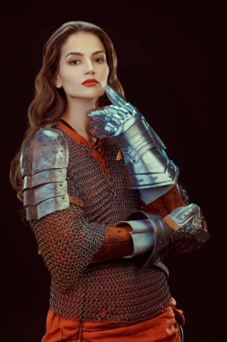Beautiful medieval woman warrior in chainmail and plate armor on a black background. clipart