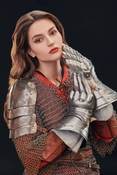 Beautiful medieval woman warrior in chainmail and plate armor on a black background.