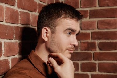 Duvarda duran yakışıklı, olgun bir adamın portresi. Yan görüş. Erkek güzelliği, moda.