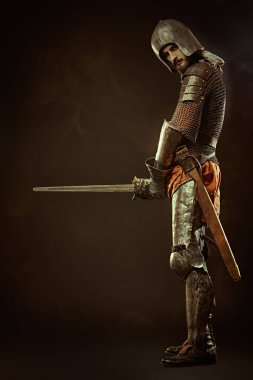Siyah arka planda kılıçlı cesur bir ortaçağ şövalyesinin tam boy portresi..