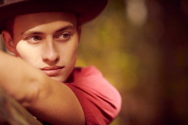 Yakışıklı bir gencin yakın plan portresi. Işıkta ve gölgede başka tarafa bakıyor. Erkek güzeli.. 