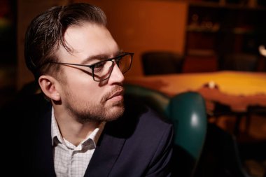 Zarif takım elbiseli ve gözlüklü kendinden emin orta yaşlı bir iş adamının portresi. Başarı ve liderlik.