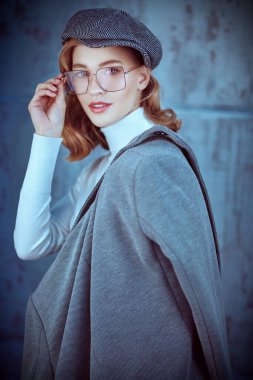 Doğal makyajlı, güzel dalgalı sarı saçlı, zarif kıyafetler giyen ve gözlüklü romantik bir genç kadın. Güzellik, moda konsepti. Optik ve gözlük tarzı.