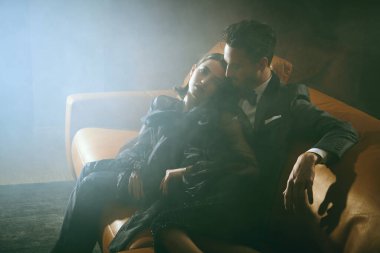 Lüks bir dairede puslu poz veren şık gece kıyafetleri içinde zarif bir çift. Göz kamaştırıcı bir yaşam tarzı. Moda fotoğrafı..