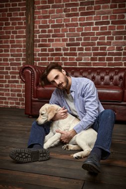 Mutlu genç adam evcil köpeği Golden Retriever ile oynuyor..