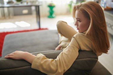 Mutlu hayat, mutlu insanlar konsepti. Güzel sarışın bir kızın portresi. Oturma odasındaki kanepede dinleniyor..