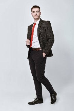 Beyaz arka planda gri takım elbiseli yakışıklı bir adam. Kopya alanı olan bir iş adamı portresi. 