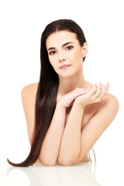 Beyaz arka planda açık renk makyajlı, güzel, çıplak esmer bir kızın portresi. Güzellik ve sağlık hizmetleri. Spa, cilt bakımı ve kozmetik ürünleri. 