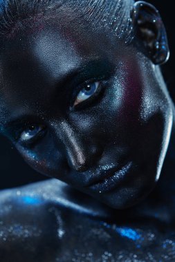 Parıltılı makyajlı güzel bir manken kadının portresi. Vücut boyama ve makyaj. Karmaşık renk ışıklandırmalı siyah arkaplan. 