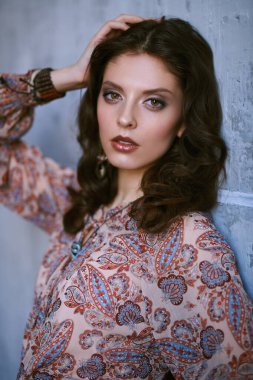 Bohem tarzı. Stüdyoda poz veren boho tarzı kıyafetler ve takılar içinde güzel bir kızın moda fotoğrafı..