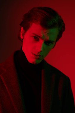 Kırmızı ışıkta zarif giysiler içinde yakışıklı bir genç adam. Erkek tarzı. Erkek güzelliği. Moda.. 