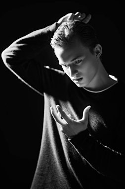Aydınlık ve karanlıkta poz veren duygusal yakışıklı adamın siyah beyaz portresi. Güzellik ve duygular.