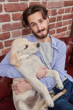 Yakışıklı genç adam evcil köpeği Golden Retriever ile vakit geçiriyor..