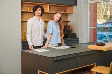 Mutlu genç çift evdeki mutfakta birlikte vakit geçiriyor. Evde aile hayatı. Modern iç mekan, mobilya.