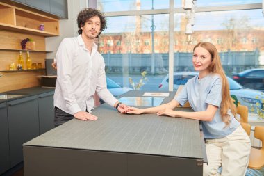 Evde aile hayatı. Mutlu genç çift evdeki mutfakta birlikte vakit geçiriyor. Modern iç mekan, mobilya.