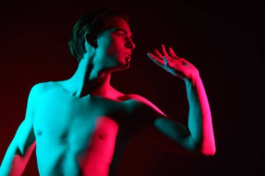 Kırmızı ve yeşil ışıkta poz veren kaslı çıplak gövdeli yakışıklı genç adam. İnsanın güzelliği ve sağlığı. Resim.. 