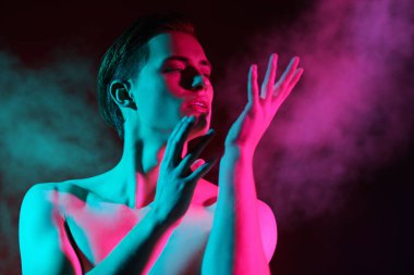 Sanat tarzı. Yakışıklı atletik genç bir adamın portresi kaslı çıplak gövdesi ile kırmızı ve yeşil ışıkta ifade ile poz veriyor. İnsanın güzelliği ve sağlığı. 