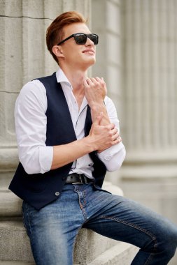 Şehir güvertesinde yürüyen yakışıklı genç adam. Yaz modası. Yaz tatili ve tatil.