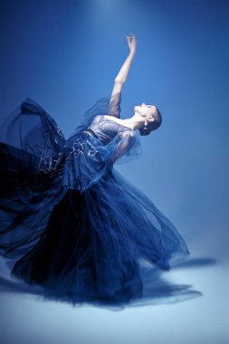 Lüks bir gece elbisesiyle dans eden güzel bir bayan balerin. Moda ve güzellik konsepti. Bale gösterisi. Tam boy stüdyo resmi.