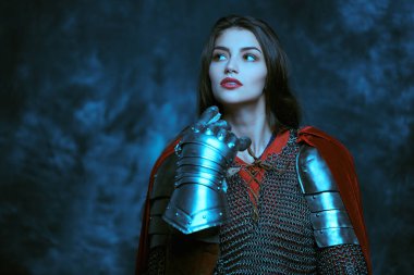 Güzel bir ortaçağ kadın savaşçısı. Zincirli zırhı ve eski bir arka planda plaka zırhı..