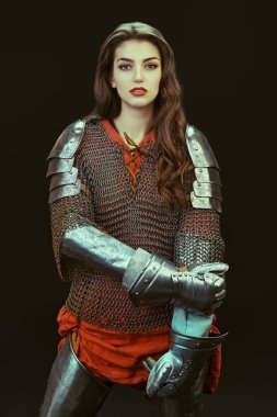 Güzel bir ortaçağ kadın savaşçısı, siyah bir arka planda zırhı ve zırhı var..