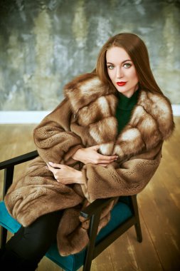 Lüks dairelerde poz veren pahalı kürklü güzel bir kadın. Moda fotoğrafı..