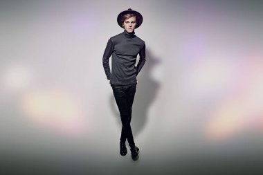 Stüdyoda şık kıyafetler içinde poz veren zarif bir gencin tam boy portresi. Moda fotoğrafı..