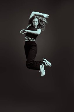 Siyah arka planda stüdyoya atlayan profesyonel balerin. Siyah-beyaz tam boy portre. 