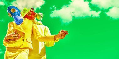 Ekolojik felaket. Parlak elbiseli ve gaz maskeli çift yeşil gökyüzüne karşı dans ediyor. Boşluğu kopyala. 