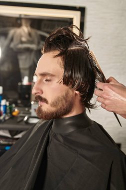 Yakışıklı esmer adam berber dükkanındaki kuaförü ziyaret etmekten hoşlanıyor. Erkeklerin güzelliği.