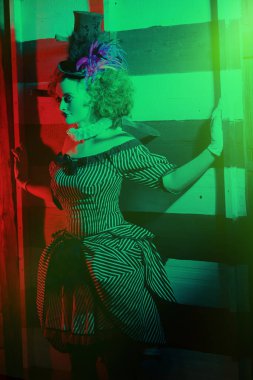 Palyaço kostümlü bir sirk sanatçısı bıçak fırlatma numarası yapar. Karanlık sirk konsepti. Retro biçimi.