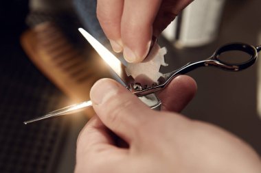 Profesyonel kuaför aleti. Berberin elleri makası ayarlar.