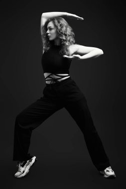 Stüdyoda siyah arka planda dans eden profesyonel bir modern dansçı kızın siyah beyaz portresi..